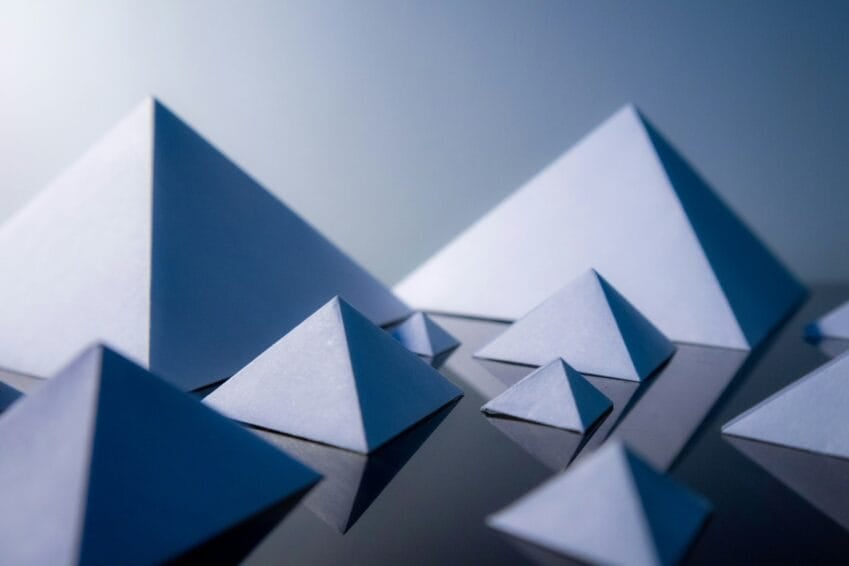 Abstract stacked pyramid shapes symbolizing a pyramid scheme's recruitment structure, illustrating the Philippines MLM vs. pyramid scheme guide