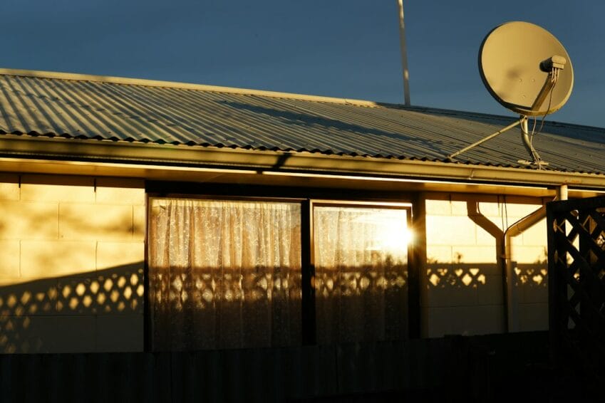 A satellite dish mounted on a home's corrugated roof for satellite internet service, used to illustrate whether Starlink is worth it in the Philippines
