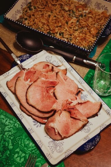 A whole glazed Christmas ham, sliced and served on a holiday dinner table, the centerpiece buying decision in this Philippine Noche Buena 2026 guide