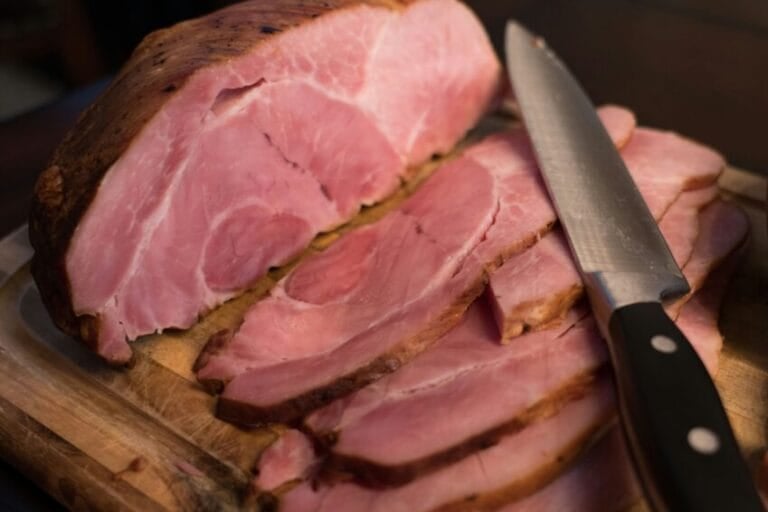 A whole Christmas ham sliced on a cutting board for a Noche Buena holiday table in the Philippines