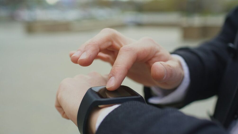 Man checking the touchscreen of a smartwatch on his wrist, illustrating the smartwatch and fitness tracker buying guide for the Philippines