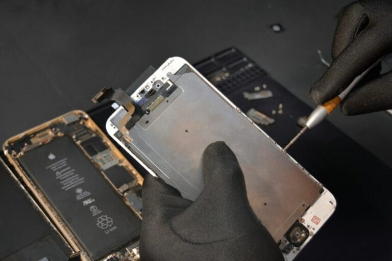 Technician repairing an iPhone at a service center — the out-of-warranty repair cost AppleCare+ can't cover in the Philippines since it isn't sold for iPhone