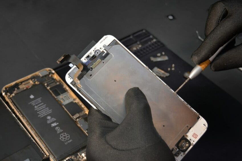 Technician repairing an iPhone at a service center — the out-of-warranty repair cost AppleCare+ can't cover in the Philippines since it isn't sold for iPhone